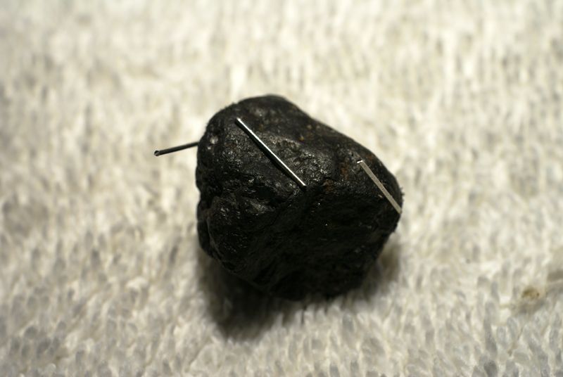 A lodestone with small pieces of metal magnetically attracted to it